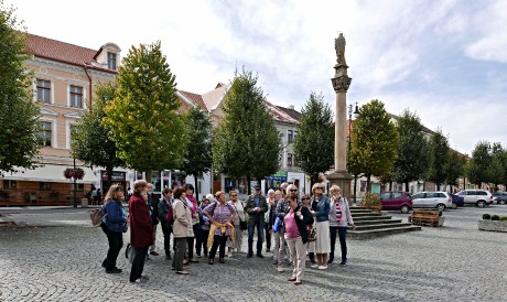 Prohlídka náměstí s průvodcem, v pozadí  Mariánský sloup